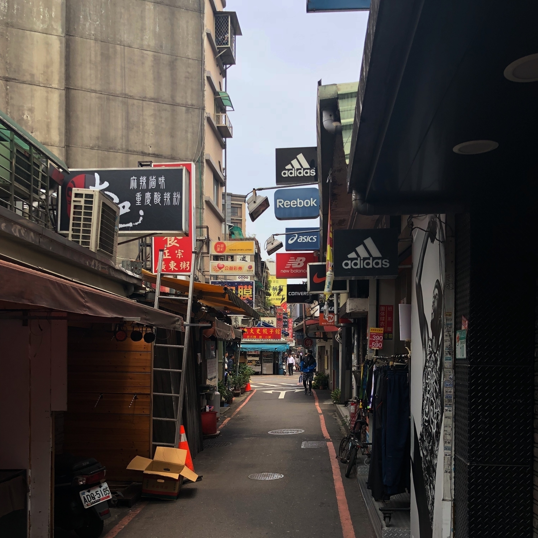 Narrow lane in Taipei with overlapping street signs.