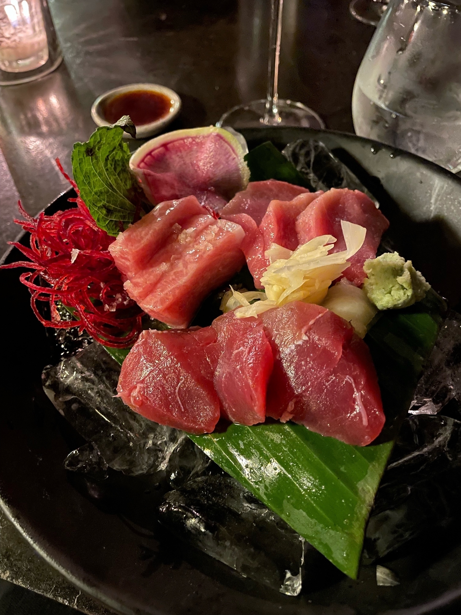 Sashimi with three kinds of tuna on banana leaf and ice.