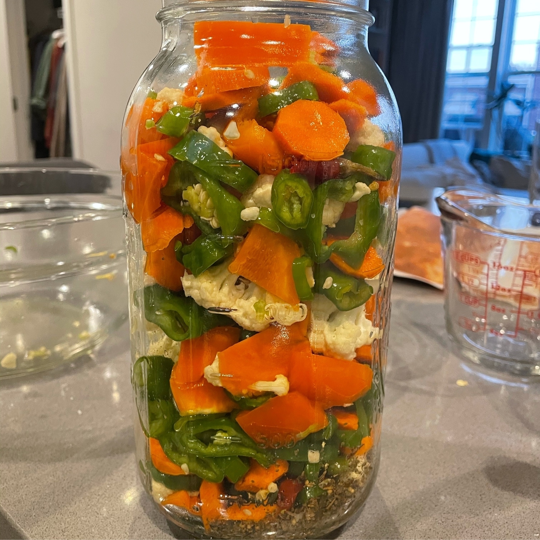 Cut vegetables (cauliflower, carrots, and peppers) in a tall mason jar.