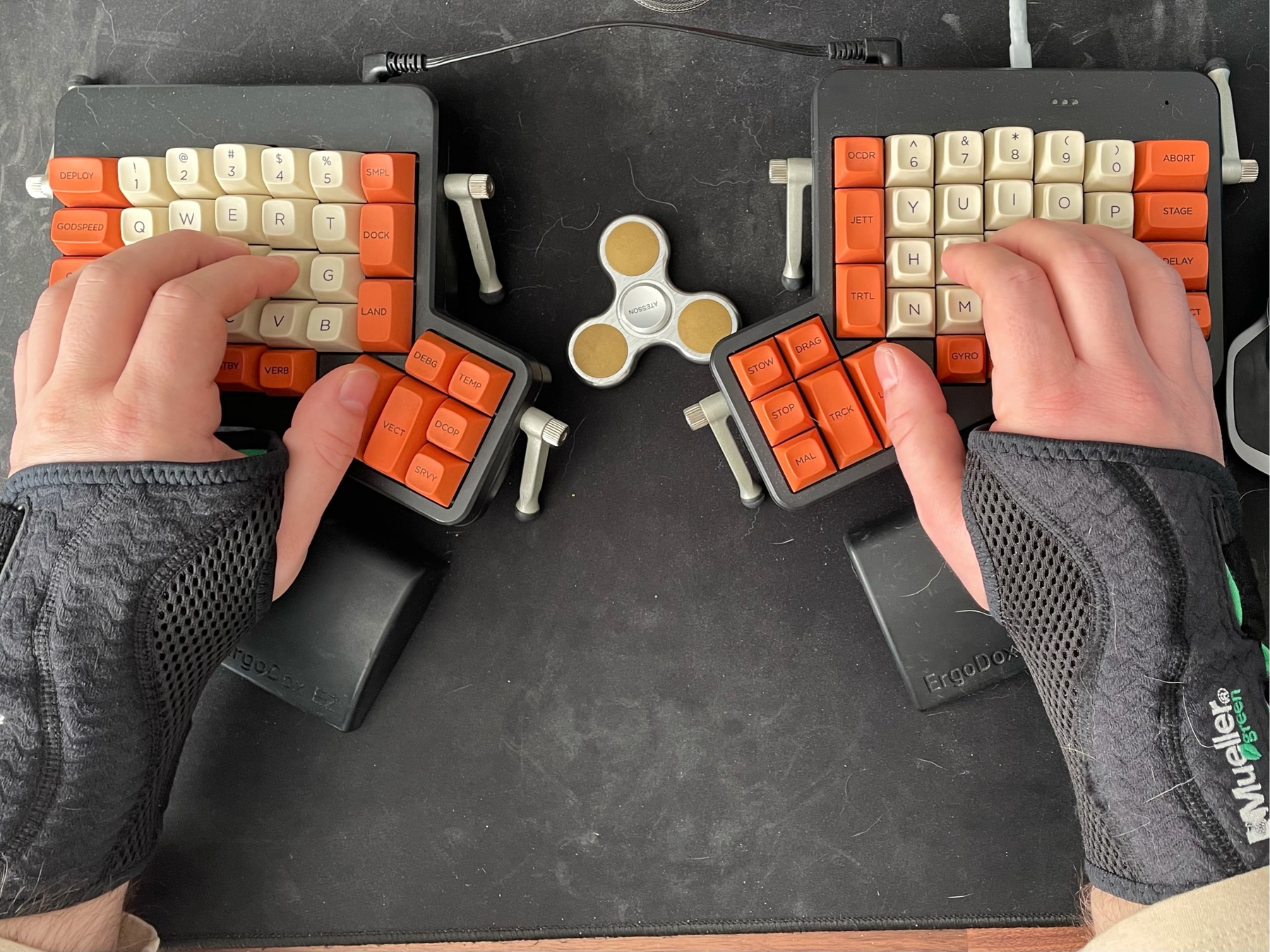 Two braced hand on an ergonomic keyboard.