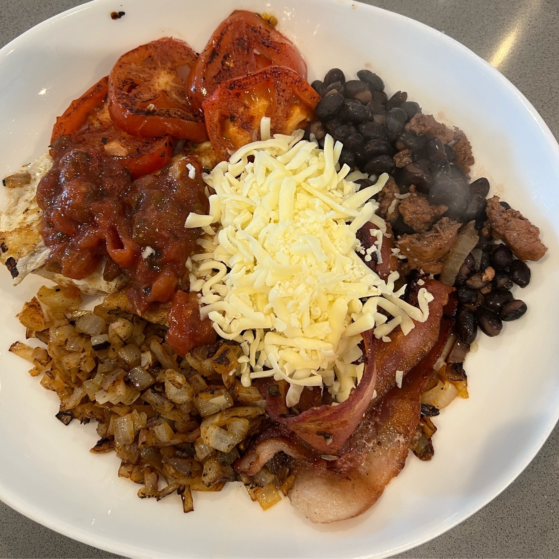 Eggs, grilled onions, grilled tomatoes, black beans and chorizo, bacon, salsa, and cheese.