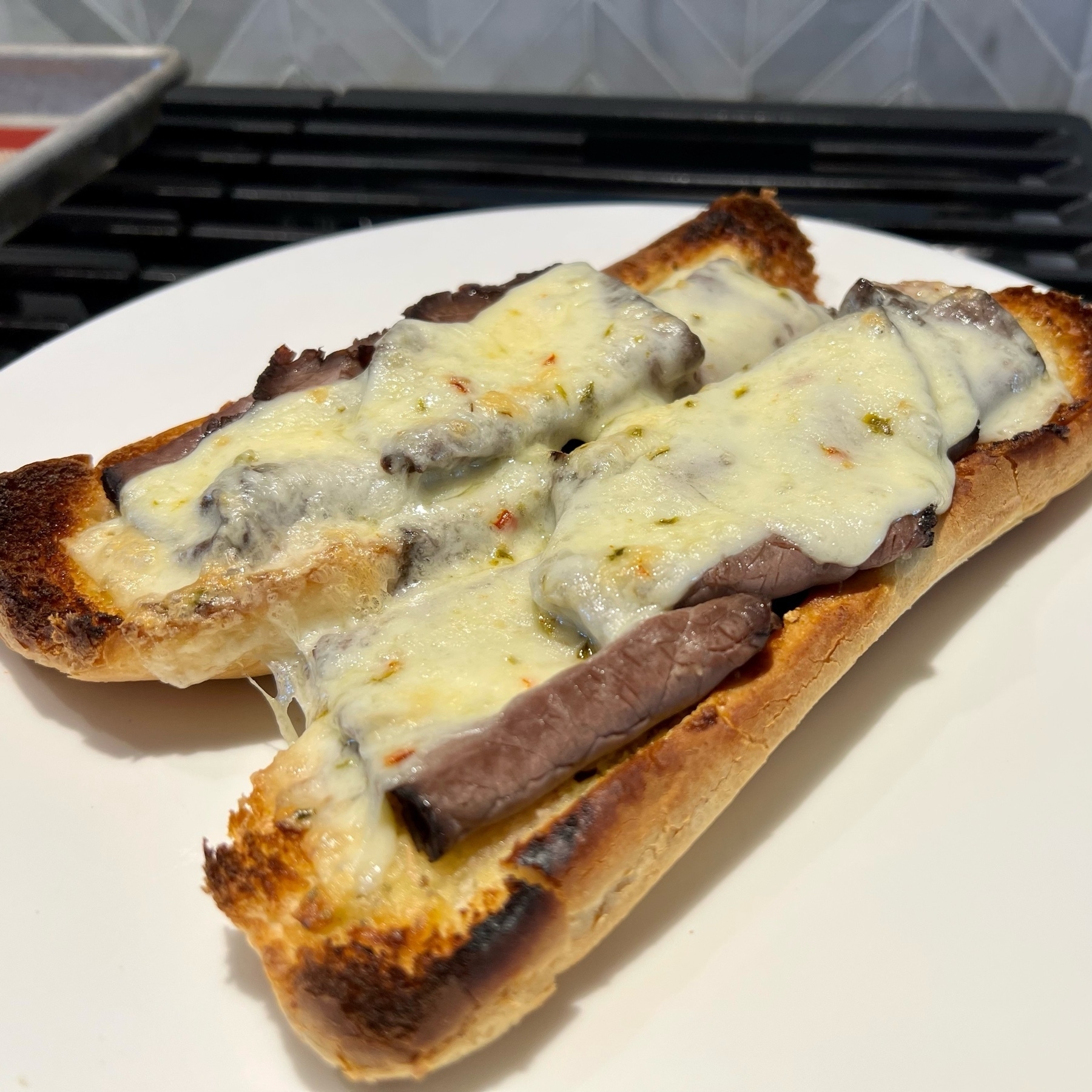 Melted cheese and roast beef on prior garlic bread.