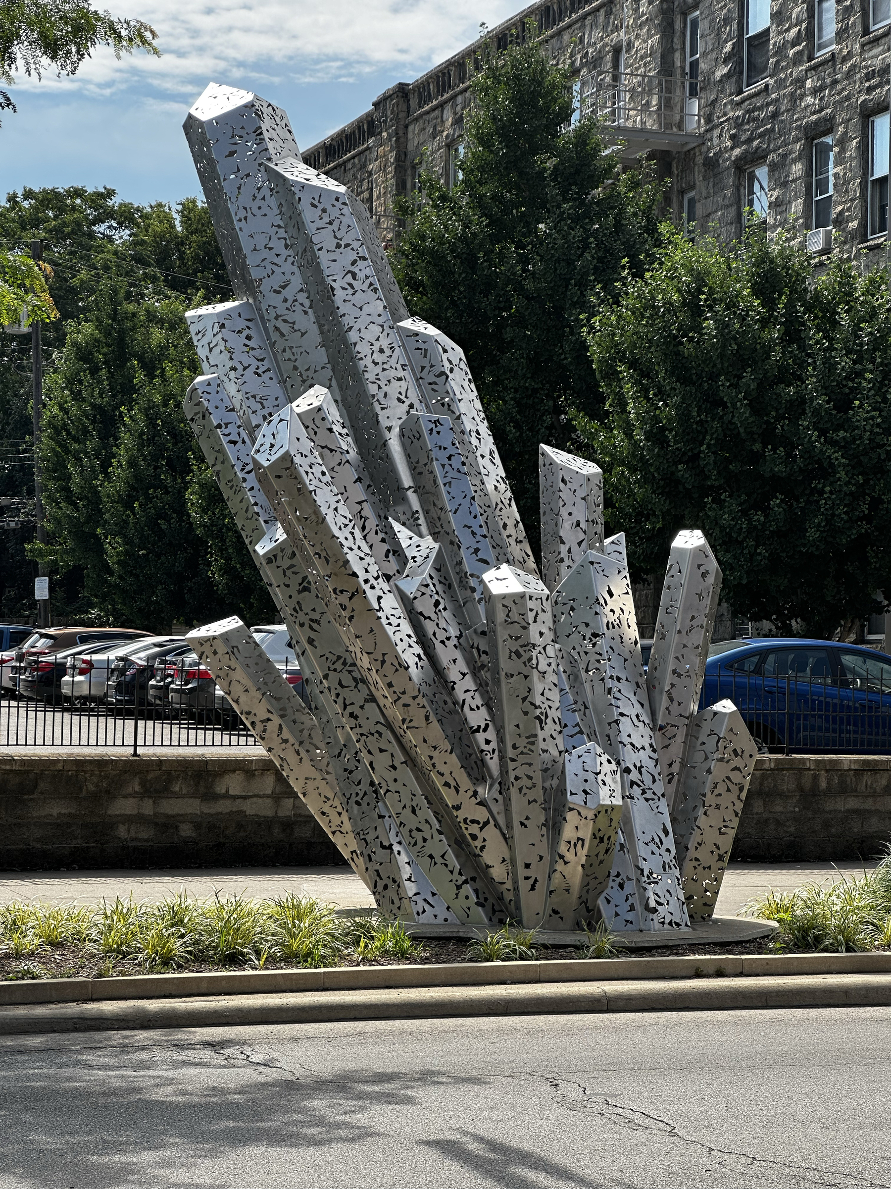 A silver sculpture on the street that has a crystal-look